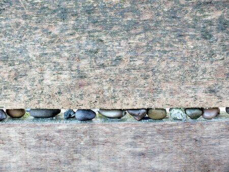 Textured background image, old pale wood with line of beach pebbles.の写真素材