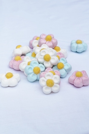 Pile of flower shaped marshmallow sweets, pink, blue ans whute candy treatの写真素材