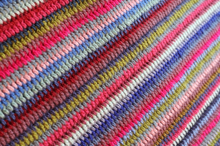 A striped crochet colourful blanket , a textile background