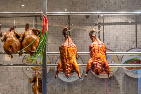 Two Delicious Homemade Roasted ducks hung in kitchenの写真素材