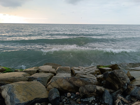 View of the Black Sea in Batumi, surrounded by large rocks, waves crashing against the rocks on the shore.の写真素材