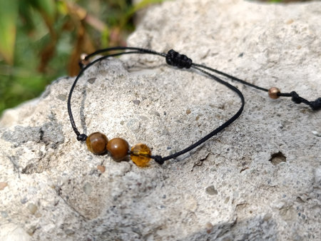 Bracelet with three natural stones. Amulet bracelet with a black thread.の写真素材
