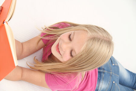 Cute little girl is reading bookの写真素材
