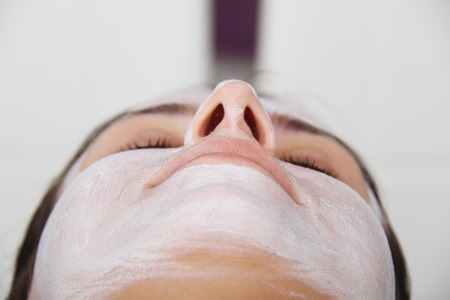 Beautiful young woman with clay facial mask