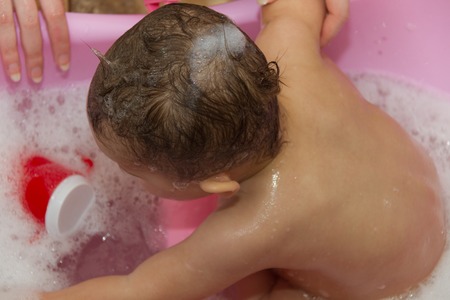 Photo of the Cute little girl bathes in a showerの写真素材