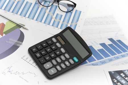 Photo of the Businessman analyzing investment charts with calculator and laptopの写真素材