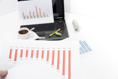 Photo of the Analyzing business investment charts with calculator and laptopの写真素材