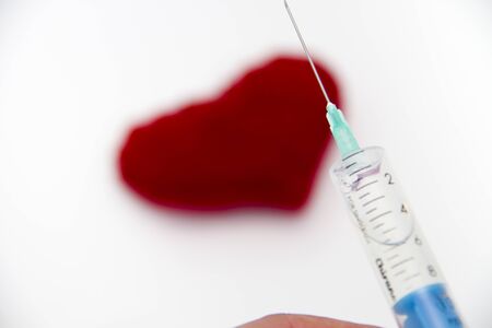 Photo of the Syringe injecting a red heart and health concept, healthy lifeの写真素材