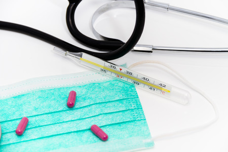 Photo of the Set for flu treatment -  pills, thermometer, nasal sprays, protective surgical mask,...