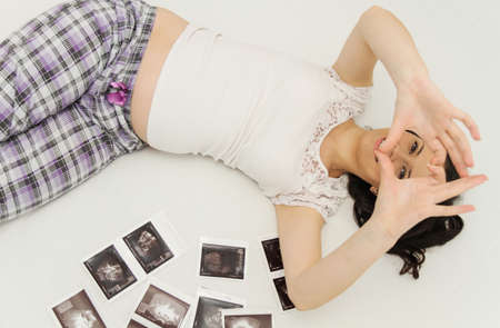 Photo of the Pregnant woman enjoy looking at ultrasound scan of babyの写真素材