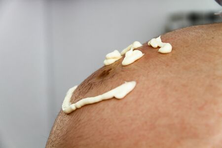 Photo of the Pregnant female with cosmetic cream on belly