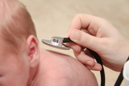 Photo of teh Male Baby gets a lung examination by a nurse with stethoscopeの写真素材