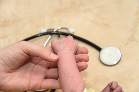 Photo of teh Male Baby gets a lung examination by a nurse with stethoscopeの写真素材