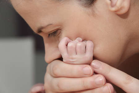 Photo of the Mother and her Newborn Baby, Parent holding newborns hands, Happy Mother and Baby togetherの写真素材