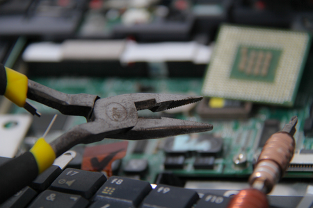 Computer repair concept Close-up view. Computer service. Man repairing notebook at the table