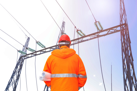 Electrical engineer looking at substation, back viewの写真素材