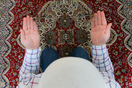 Young muslim man praying inside of beautiful mosqueの写真素材