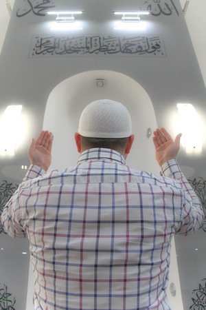 Young muslim man praying inside of beautiful mosqueの写真素材
