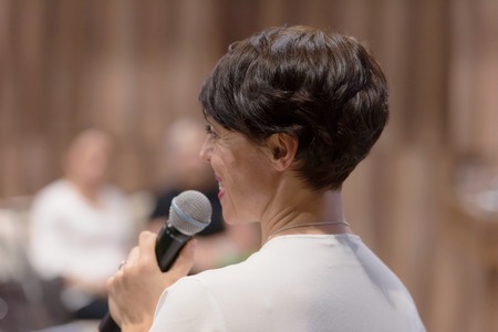 Beautiful business woman with microphone in her hand speaking at the  conference or seminar.の写真素材