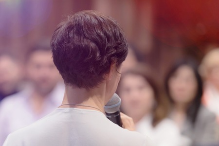 Beautiful business woman with microphone in her hand speaking at the  conference or seminar.の写真素材