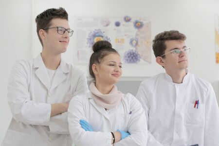 Group of young Laboratory scientists working at lab with test tubes and microscope, test or research...