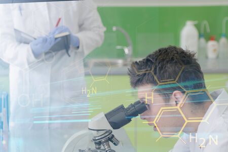 Two Young male Laboratory scientists working at lab with test tubes and microscope, test or research...