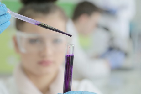 Two Young Female and male Laboratory scientists working at lab with test tubes and microscope, test or research in clinical laboratory.Science, chemistry, biology, medicine and people concept.の写真素材