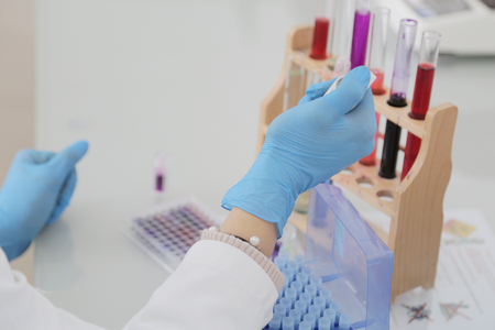 Young female Laboratory scientist working at lab with test tubes and microscope, test or research in clinical laboratory.Science, chemistry, biology, medicine and people concept.の写真素材