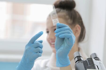Young female Laboratory scientist working at lab with test tubes and microscope, test or research in...