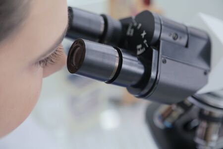 Young female Laboratory scientist working at lab with test tubes and microscope, test or research in clinical laboratory.Science, chemistry, biology, medicine and people concept.の写真素材