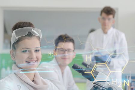 Group of young Laboratory scientists working at lab with test tubes and microscope, test or research in clinical laboratory.の写真素材