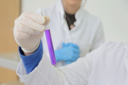Group of young Laboratory scientists working at lab with test tubes and microscope, test or research in clinical laboratory.Science, chemistry, biology, medicine and people concept.の写真素材