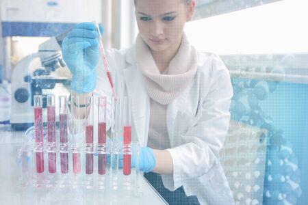 Young female Laboratory scientist working at lab with test tubes and microscope, test or research in clinical laboratory.Science, chemistry, biology, medicine and people concept.の写真素材