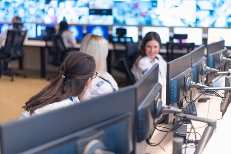 Security guard monitoring modern CCTV cameras in surveillance room. Group of  Female security guards in surveillance room.の写真素材