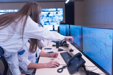 Security guard monitoring modern CCTV cameras in surveillance room. Group of  Female security guards...
