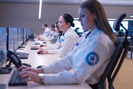 Security guard monitoring modern CCTV cameras in surveillance room. Group of  Female security guards in surveillance room.の写真素材