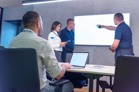 Group of security guards working on computers while sitting in the main control room, CCTV surveillance.の写真素材