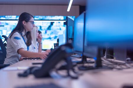 Group of security guards working on computers while sitting in the main control room, CCTV surveillance.の写真素材