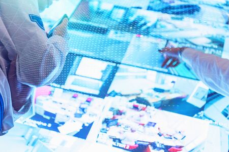 Group of security guards working on computers while sitting in the main control room, CCTV surveillance.の写真素材