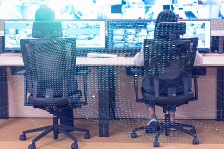 Group of security guards working on computers while sitting in the main control room, CCTV surveillance.の写真素材