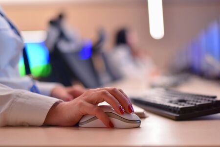 Security guard monitoring modern CCTV cameras in surveillance room. Female security guard in surveillance room. Female security guard holding phone  in hand at workplace.の写真素材