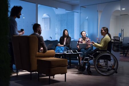 Handicapped young woman with colleagues working in office. She is smiling and passionate about the...