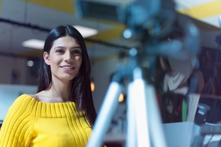 Giving advice. Beautiful young woman smiling while making social media video, Recording her self and streaming to online platform.の写真素材