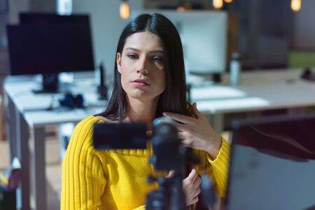 Giving advice. Beautiful young woman smiling while making social media video, Recording her self and streaming to online platform.の写真素材