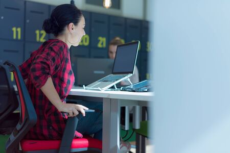 Two Young female business women using laptopat her work and staying alone after work to finish her job.の写真素材