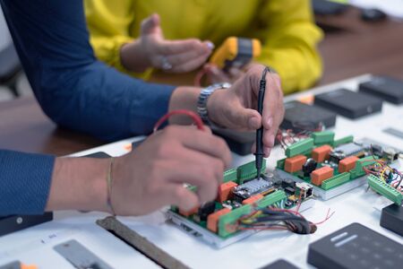 Two young handsome engineers working on electronics components.Tech tests electronic equipment in service center. Technologically Advanced Scientific Research Center.の写真素材