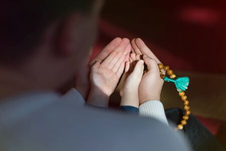 Muslim father and son praying together. Muslim dad and son praying in the mosque.