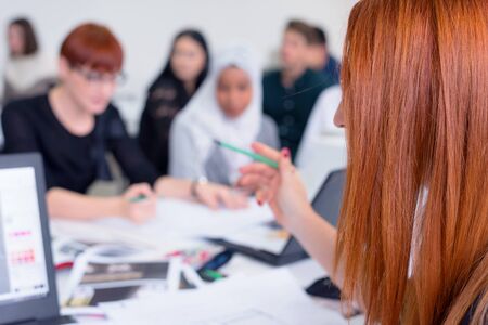 Female redhead Professor Holding Lecture to Multi Ethnic Group of Students. Smart Young People Studying at the University.の写真素材