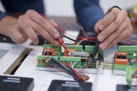 Two young handsome engineers working on electronics components.Tech tests electronic equipment in service center. Technologically Advanced Scientific Research Center.の写真素材