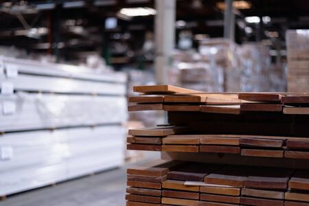 Timber Flooring Factory. Pile of cut wood in factory storage warehouse. Lumber in warehouse.